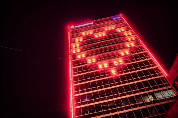 Ein Hochhaus mit roter Beleuchtung in Herzform bei Nacht.